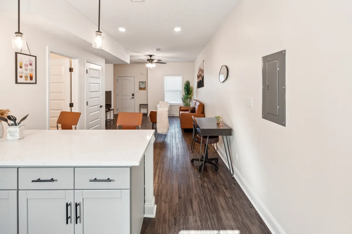 A view that blends the kitchen island, living area, and dining table, highlighting the seamless flow between spaces. The atmosphere is inviting, ideal for sharing meals, hosting friends, or enjoying quiet evenings.